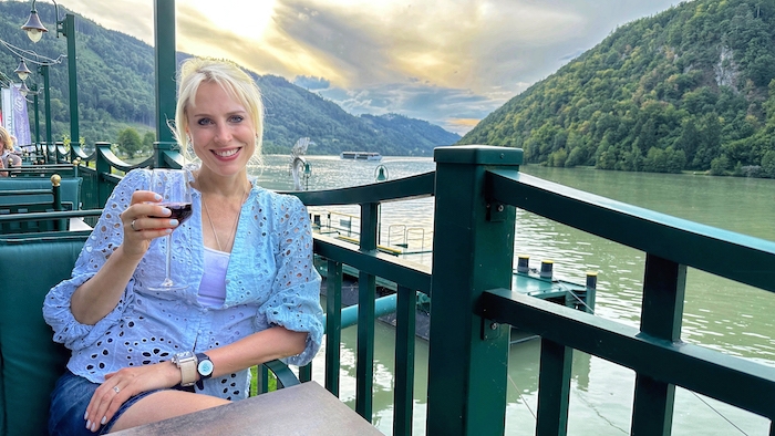 Elischeba Wilde mit einem Glas Rotwein auf der Terrasse mit Blick auf die Donauschlinge