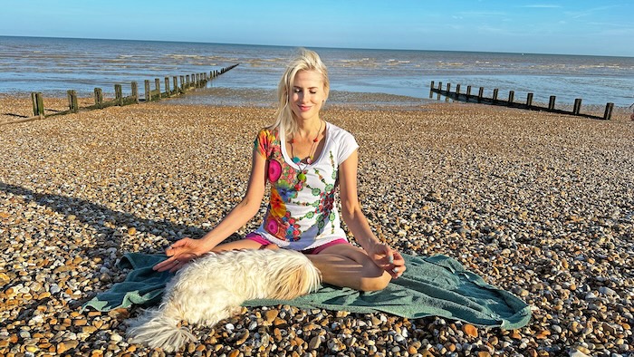 Elischeba mit Hund beim Yoga am Strand von Littlestone in Kent