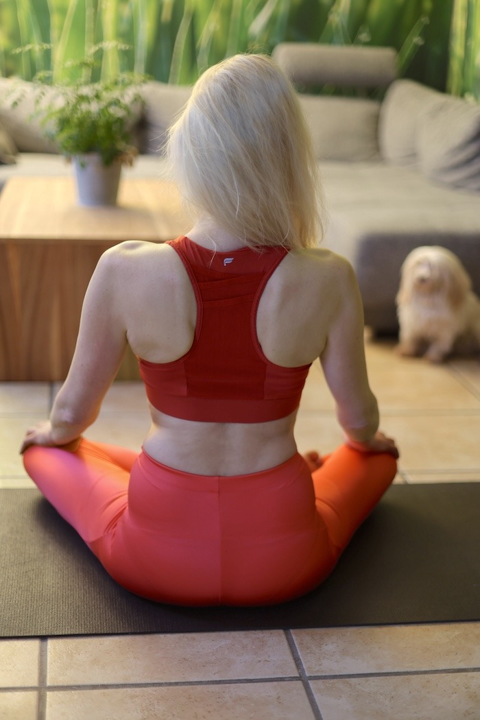 Elischeba Wilde im roten Yogaoutfit - Rückenansicht