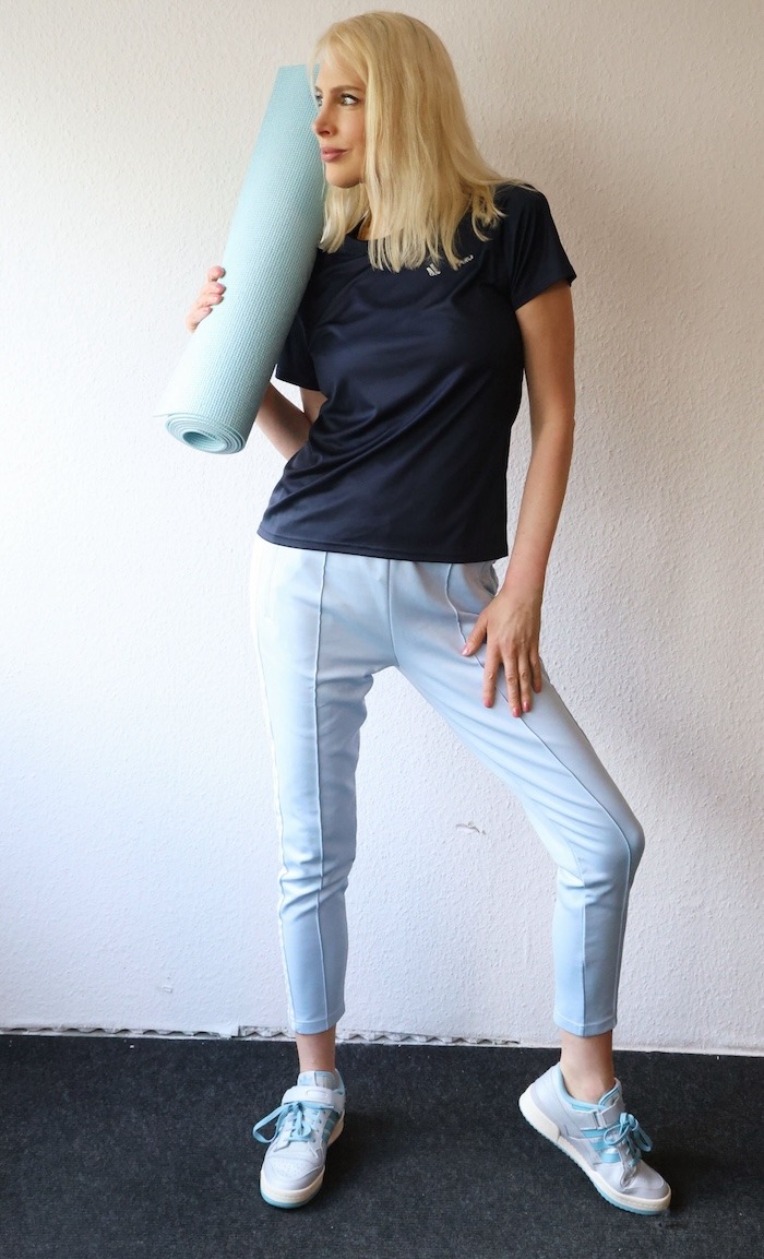 Elischeba Wilde im blauen Sportoutfit mit Sneaker von ADIDAS